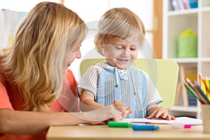 Mother and child of three years having fun painting at home