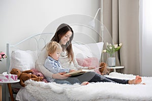 Mother and child, toddler boy, reading book in bed