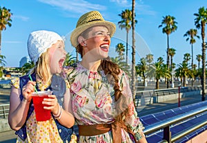 Mother and child tourists with bright red beverage looking into