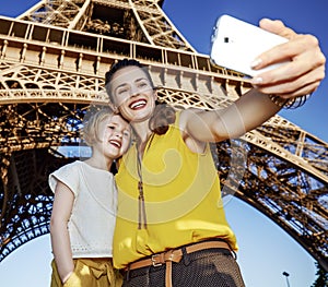 Mother and child tourists taking selfie against Eiffel tower