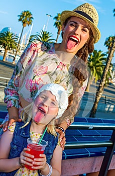 Mother and child travellers showing tongues after drinking