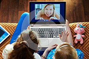 Mother and child using computer for video call on laptop