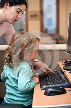 Mother and child using a desktop computer