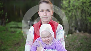 Mother with a child are walking in the park near the lake at sunset