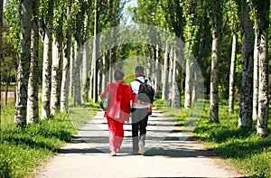 Mother and child walking together in summer city park