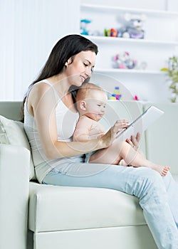 Mother and child want to play and read tablet computer on sofa