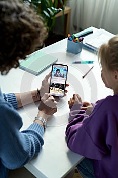 Mother with child watching video on smartphone