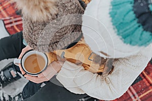 Mother and child on a winter walk outdoors drinking tea