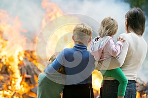 Mother with children at burning house background