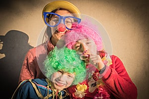 Mother and children in carnival mask smiling togheter outdoor