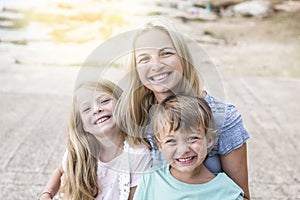 Mother with children cuddling on the beach