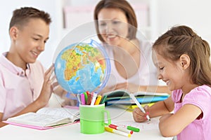 Mother with children doing homework at home photo