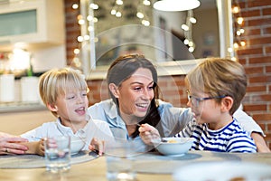 Mother with children eating breakfast