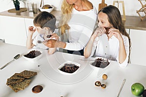 Mother children eating healthy breakfast home kitchen Happy loving family