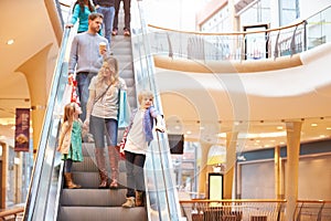 Mother And Children On Escalator In Shopping Mall