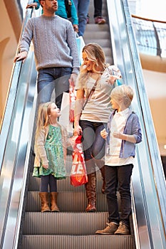 Mother And Children On Escalator In Shopping Mall