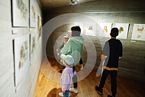 Mother with children exploring expositions in museum halls