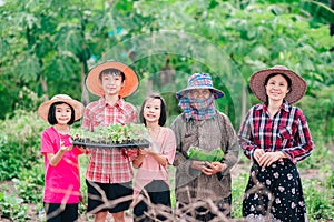 Mother and children family holding seeding plants to planting tree on blurred green nature background