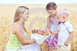 Mother with children on a field of wheat