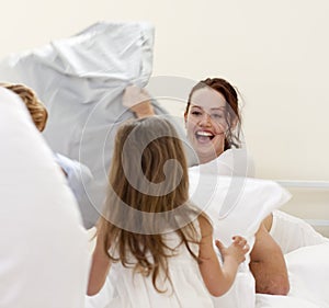 Mother and children having a pillow fight