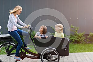 Mother and children having a ride with cargo bike