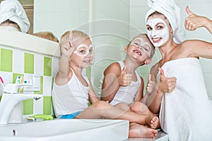 Mother and children make a face mask in the morning.The boys joke with mom. Beauty treatments for the skin