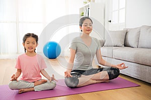 Mother with children meditating doing yoga