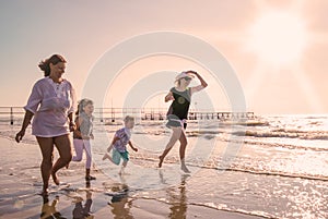 Mother and children are playing in the sea on the beach