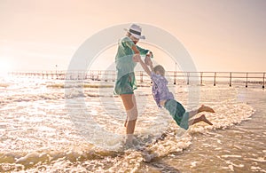 A mother and children are playing in the sea on the beach