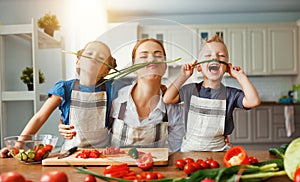 Mother with children preparing vegetable salad