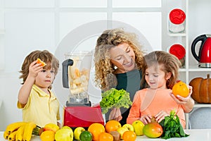 Mother and children are preparing the vegetables and fruit. Happy loving family. Healthy smoothie. Spinach smoothie