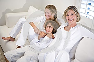 Mother and children relaxing on white sofa photo