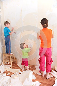 Mother with children remove old wallpapers photo