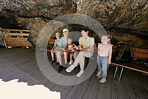 Mother with children sit on bench in Liechtensteinklamm or Liechtenstein Gorge, Austria