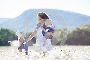 Mother with children in a summer field of blooming daisies