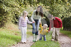 Mother and children walking along woodland path