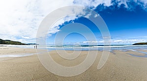 Mother and children are walking on sandy Atlantic beach.