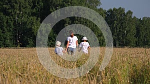 Mother with Children Walking in a Wheat Field