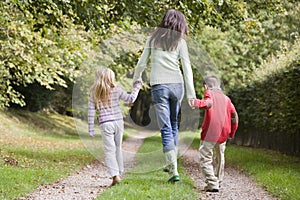 Mother and children walking on woodland path