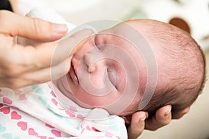 Mother cleaning eyes of a newborn baby