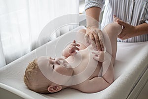 Mother cleaning her 4 month baby. Nappy changing. Child personal hygiene. Morning babycare routine photo