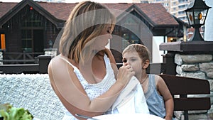 Mother cleaning mouth to her son.