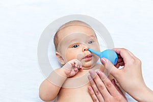 Mother cleaning the nose of a newborn with a clyster