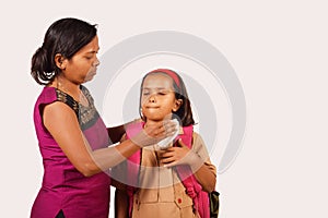 Mother cleans daughter`s face with tissue. Daughter in school uniform. Pune, Maharashtra