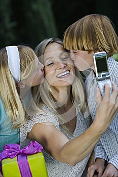 Mother Clicking Self Photo While Kids Kissing photo