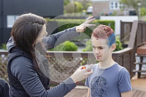 Mother coloring her sons hair