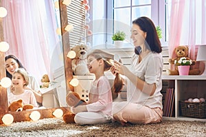 Mother is combing her daughter`s hair