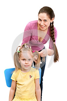 Mother is combing a little daughter