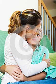 Mother comforting teenage boy