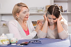 mother comforts her adult daughter